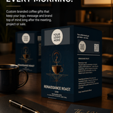 Custom branded coffee gift boxes shown on a dark wooden table in a cafe-like setting, with a coffee mug, notebook, and pen in the foreground. Large promotional text at the top reads, 'HAVE COFFEE WITH YOUR CUSTOMERS EVERY MORNING.