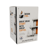 A box of Design Fuel 100% roasted coffee, featuring a white packaging design with black text, orange accents, and architectural line drawings.