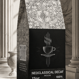 A stand-up coffee bag labeled 'NEOClassICAL DECAF' and 'MEDIUM 100% ROASTED COFFEE' stands on a stone pedestal in an ornate interior with classical columns and soft window light.